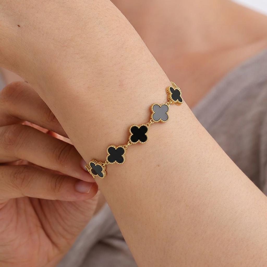 Modelo usando Pulseira em Aço Dourado com 5 Trevos Pretos